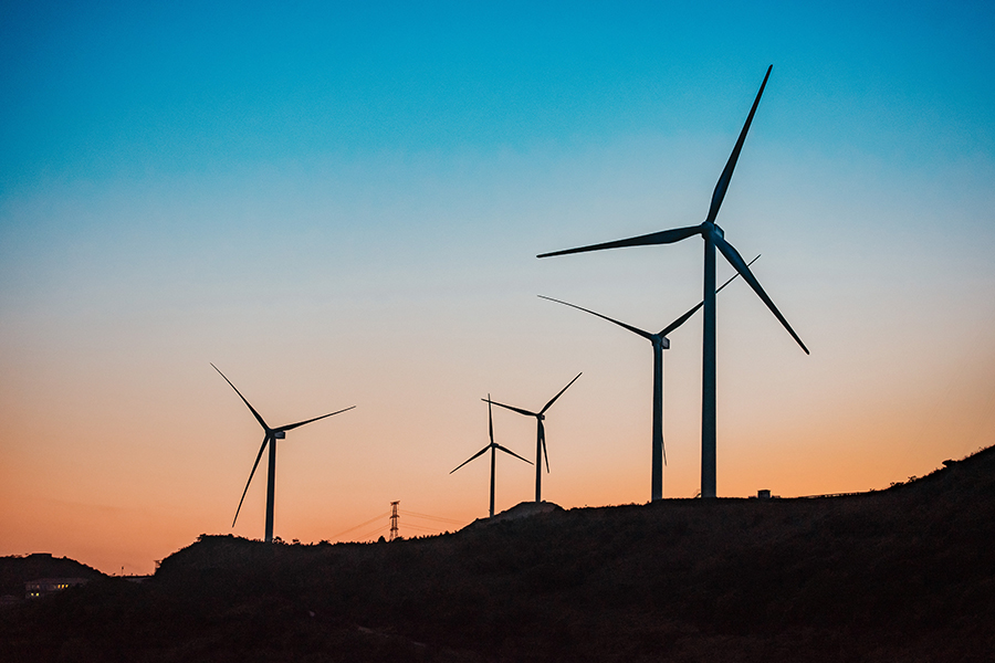 Wind turbines with a sun setting behind them