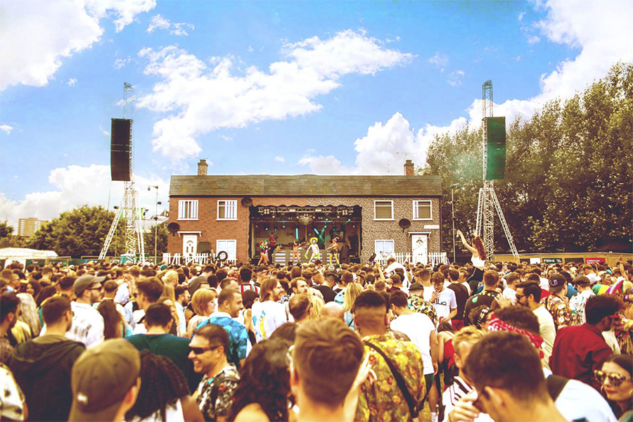 Main stage at arts house festival, designed to look like a council house with DJ's performing from the middle of the house